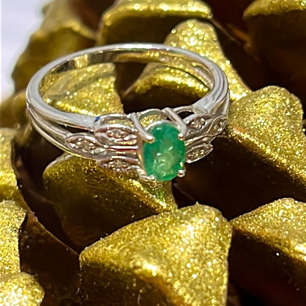 Emerald, oval-cut, set in 10 k white gold with 6 Diamond accents